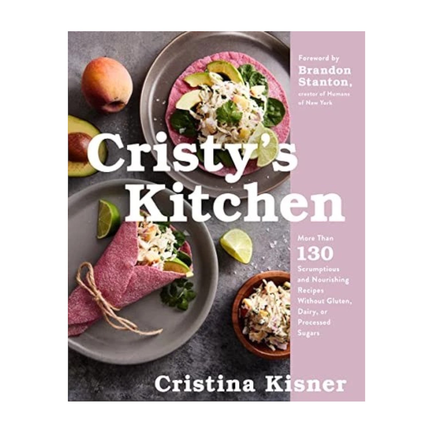 The cover of "Cristy's Kitchen" by Common Ground displays tacos, limes, a peach, and a pink napkin on grey, highlighting its collection of gluten-free recipes from the author's healthy café.