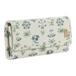 The TRVL Design Luxe Jewelry Wallet is cream-colored with a blue and green floral pattern and a gold emblem on the flap, making it an elegant, stylish travel jewelry organizer.