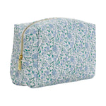 The Luxe Everyday Cosmetic Bag by TRVL Design features a blue and green floral pattern on white, a gold zipper, and a spacious rectangular shape—ideal for use as a stylish toiletry or makeup pouch.