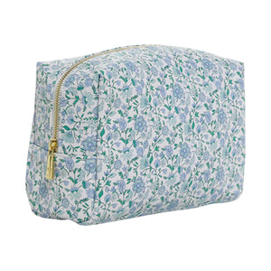 The Luxe Everyday Cosmetic Bag by TRVL Design features a blue and green floral pattern on white, a gold zipper, and a spacious rectangular shape—ideal for use as a stylish toiletry or makeup pouch.