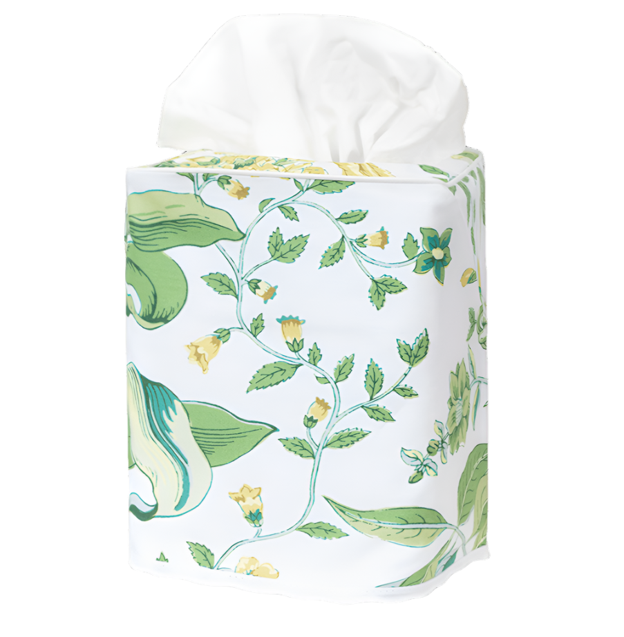 The Matouk Pomegranate Citrus Tissue Box Cover features a green and yellow floral pattern on white Egyptian cotton percale, inspired by Schumacher’s archive, wrapping a rectangular tissue box with tissues emerging from the top.