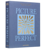 The PrintWorks Blue Picture Perfect Photo Album features gold and light blue text with a gold abstract design, making it a stylish coffee table album and an elegant home decor accent.