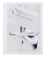 A person in white gloves offers a silver tray with an envelope marked "from your Butler" and "RAFFLES," showcasing British elegance and Asian allure. The book is titled "Raffles" by Assouline.