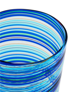 Close-up of a Murano Rainbow Swirl Tumbler by Aquazzura Casa, handblown in Italy with horizontal blue, cyan, and white stripes on a white background.