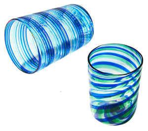 Two Murano Rainbow Swirl Tumblers by Aquazzura Casa—one upright, one on its side—display blue and green stripes, standing out against a white background.