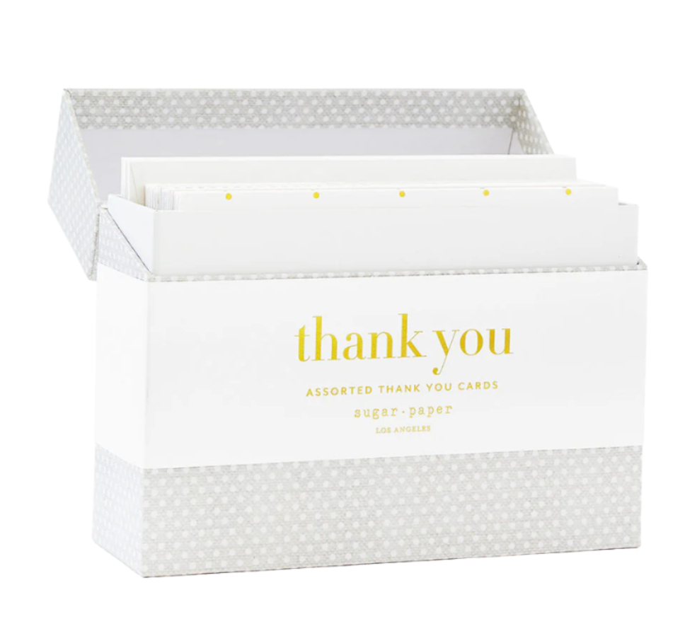 The Sugar Paper Thank You Card Box Set includes assorted cards with a white label reading "thank you" in yellow and features elegant gold foil details.