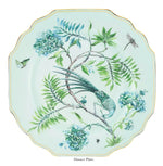 From the Aquazzura Casa Secret Garden Dinnerware and Serveware Collection, this porcelain dinner plate showcases a green bird, butterfly, dragonfly, blue-green flowers on a pale background with scalloped edge and gold details.