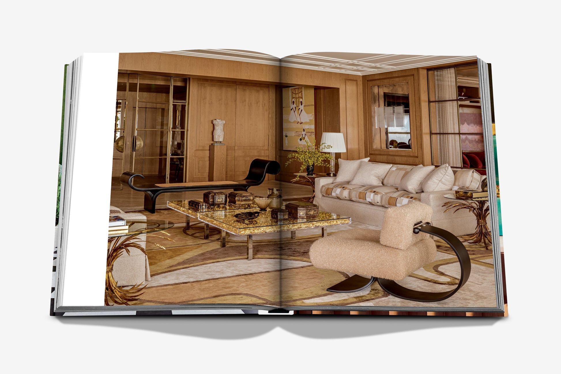 A spread from Assouline's "Sig Bergamin Eclectic" showcases an interior with a beige sofa, stylish chairs, a glass coffee table, and wooden walls echoing the designer's creative vision.
