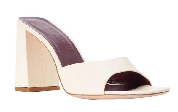 A pair of white leather mule sandals with a chunky block heel, the Staud Sloane Heel.