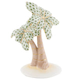 The Herend Palm Tree porcelain figurine features two palm trees with green patterned leaves and gold accents on an oval white base, highlighting hand-painted designs and elegant detailing.
