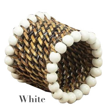 The Calaisio Woven Napkin Ring is handmade by artisans from South Pacific water-vines, detailed with white beads along the edges. Labeled "White" below.