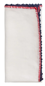 The Knotted Edge Napkin Set by Kim Seybert features white 100% linen napkins with hand-crocheted red and blue edging.