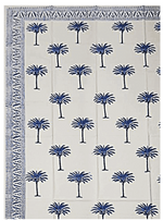 The Blue Palm Trees Tablecloth by Les Ottomans showcases a traditional blue palm tree block print and a decorative blue border on two edges.