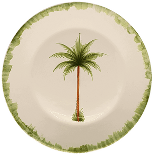 The Palm Tree Dinnerware Collection by Les Ottomans features a cream ceramic plate with a green rim and hand-painted tropical tree, crafted in Italy.