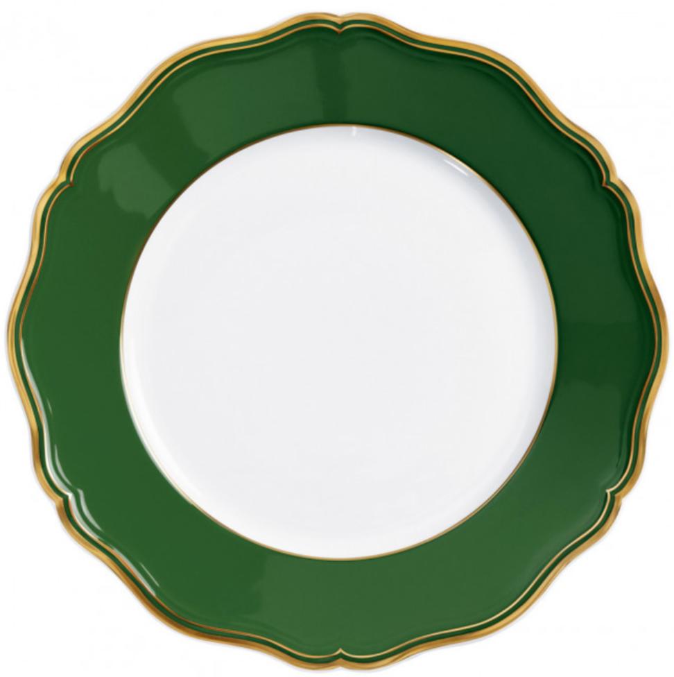 A round porcelain plate from Raynaud’s Mazurka Or Fond Vert Dinnerware Collection features a scalloped edge, wide green border with gold trim, and a hand painted white center.