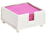 The Hampton Faux Bamboo Napkin Holder by Two's Company features a charming bamboo design and securely holds pink napkins, adding elegance to any table setting.