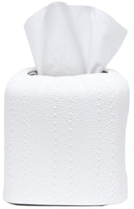 A roll of white toilet paper from the Hilo Bath Collection by Pigeon & Poodle, with a tissue pulled halfway out from the center, rests on a porcelain surface.