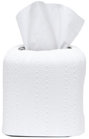 A roll of white toilet paper from the Hilo Bath Collection by Pigeon & Poodle, with a tissue pulled halfway out from the center, rests on a porcelain surface.