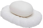 A white soap sits on the Hilo Bath Collection’s textured oval porcelain dish by Pigeon & Poodle, both in shades of white with a subtle sea urchin motif, against a plain background.