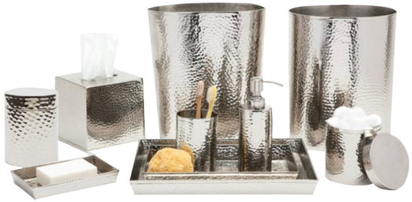 A collection of hand-hammered Pigeon & Poodle Verum Collection bathroom accessories including a tray, dispensers, and containers.