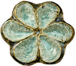 The AE Ceramics Oyster Platter Collection features six shell-shaped compartments with a greenish-blue glazed finish, ideal for serving Oysters Rockefeller or oysters on the half shell.