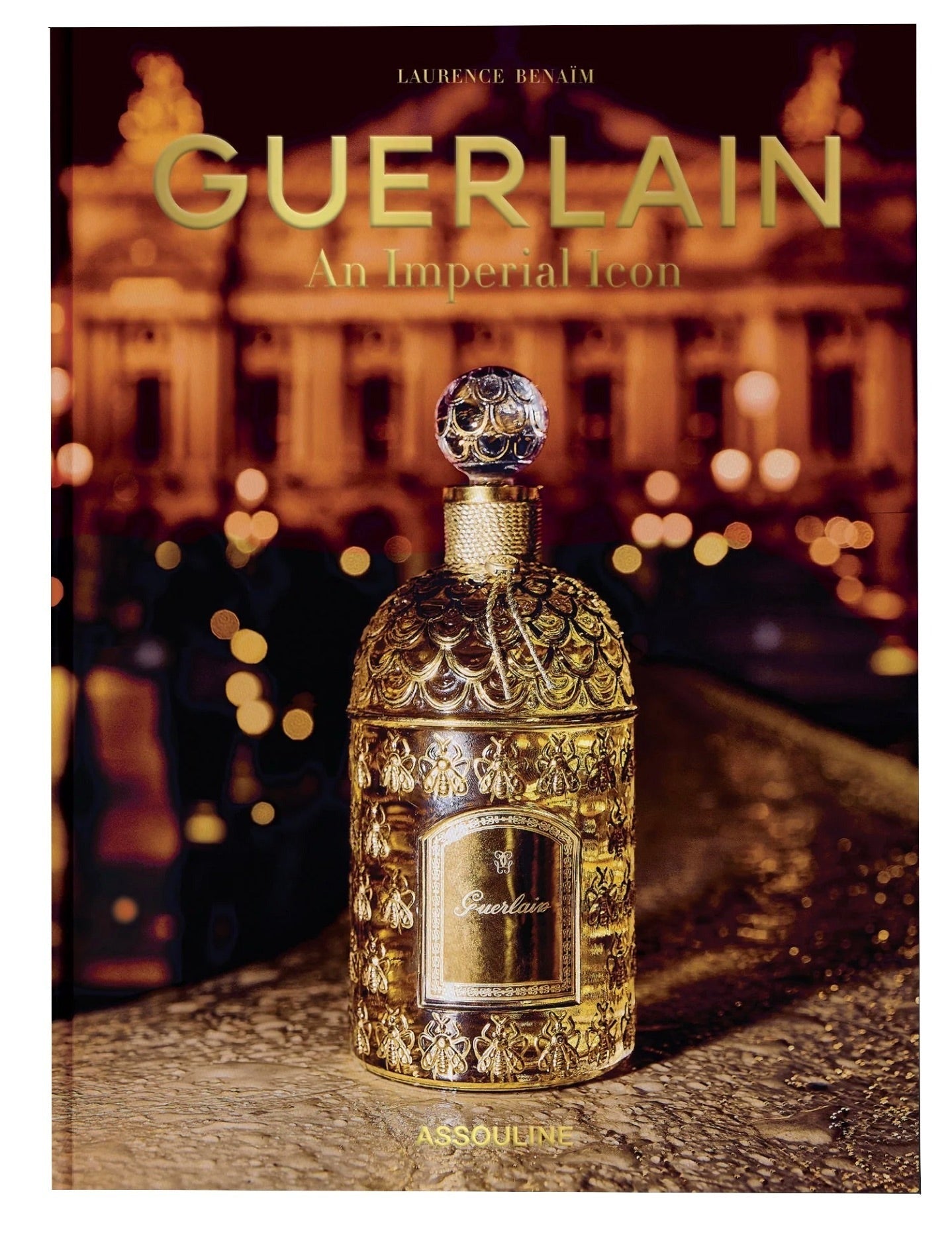 Cover of the book "Guerlain An Imperial Icon" by Assouline featuring a gold ornate Bee Bottle of perfume in front of a blurred nighttime background.