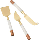 The Be Home White Marble and Acacia Gold Cheese Set includes three cheese knives with gold blades, acacia wood, and white marble handles—an elegant match for serving boards.