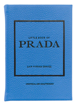 A blue book titled "Little Book of Prada" by Graphic Image, labeled as unofficial and unauthorized, details the history of the luxury fashion house.