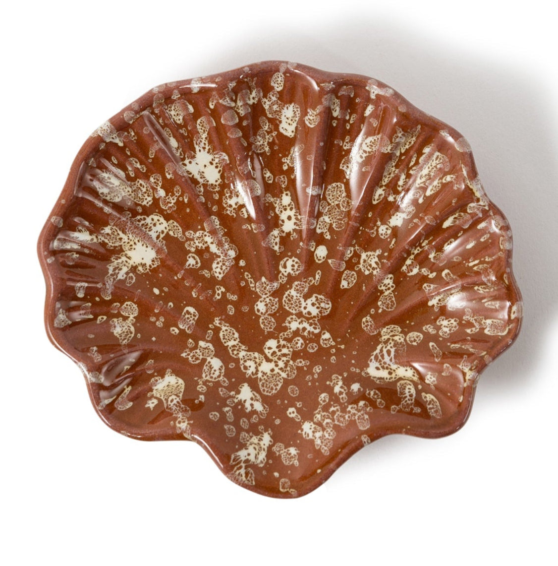 The Splatter Coquillage Dish Collection by Sharland England features a brown, scallop-shaped ceramic shell dish with white speckles—a chic, handmade-in-Italy gift shown on a white background.