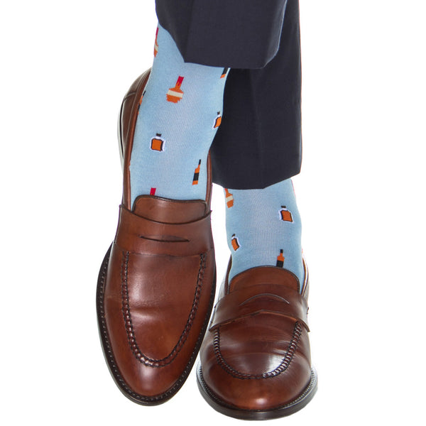 Person wearing Dapper Classics Bourbon Bottles Mid Calf Socks in Sky Blue against a white background.