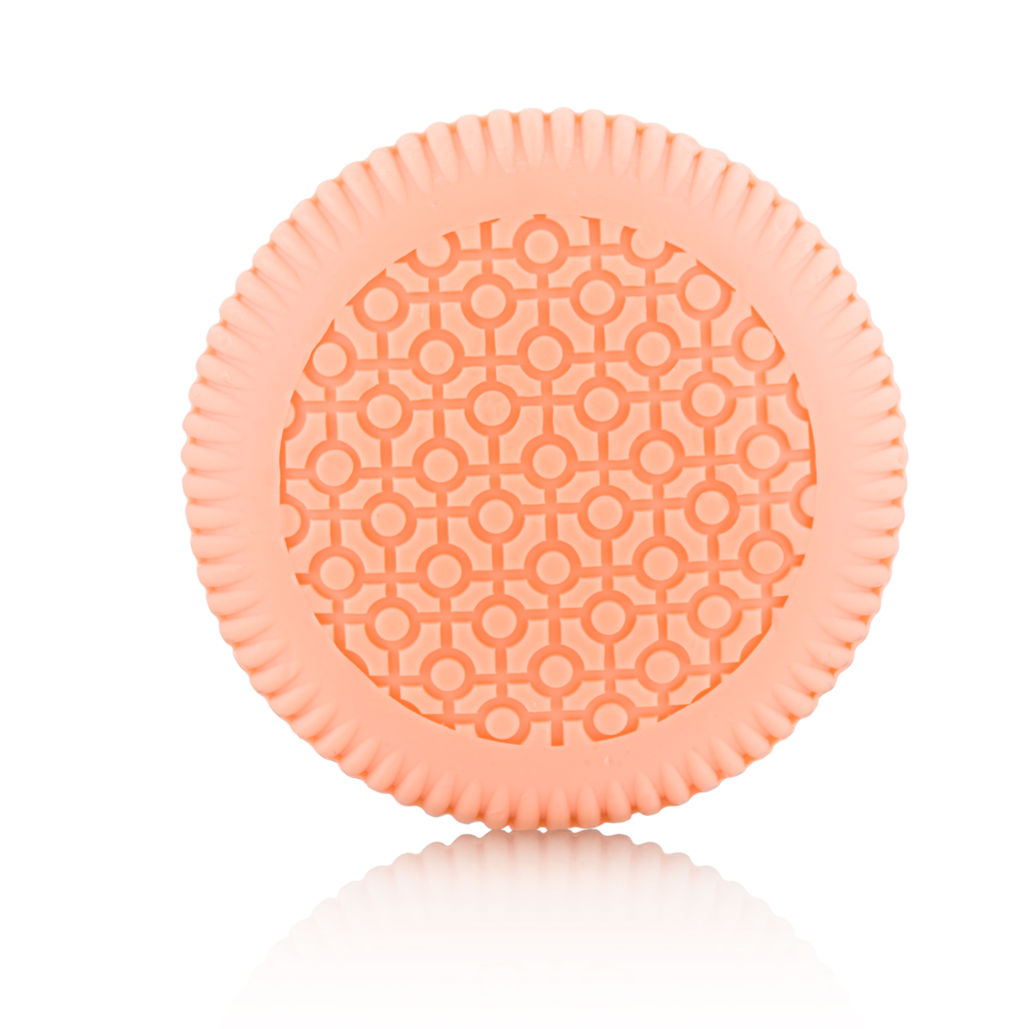 A round, light orange item with a patterned surface and ridged edges from Baobab Collection Women Body Wellness Collection by Baobab, shown on a white background, evoking the softness of a women’s floral fragrance.
