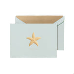 The Crane Thank You Gold Starfish Folded Card Set features a light blue Beach Glass card with a metallic gold starfish design and comes with a matching gold-lined envelope.