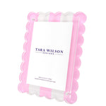 The Scallop Stripe Frame by Tara Wilson Designs features scalloped pink edges, clear lucite, and a white card insert—an elegant addition inspired by our best-selling frame collection.