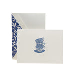 The Crane Tea Cups Card Set includes pearl white folded notes with an illustration of three stacked blue teacups and saucers, each paired with a blue and white toile-lined envelope—ideal for thoughtful thank-you notes.