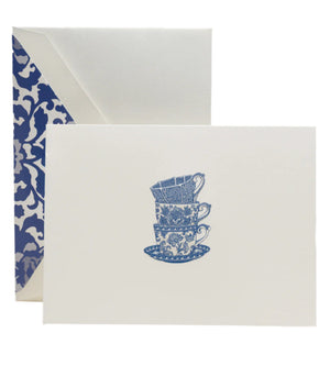 The Crane Tea Cups Card Set includes pearl white folded notes with an illustration of three stacked blue teacups and saucers, each paired with a blue and white toile-lined envelope—ideal for thoughtful thank-you notes.