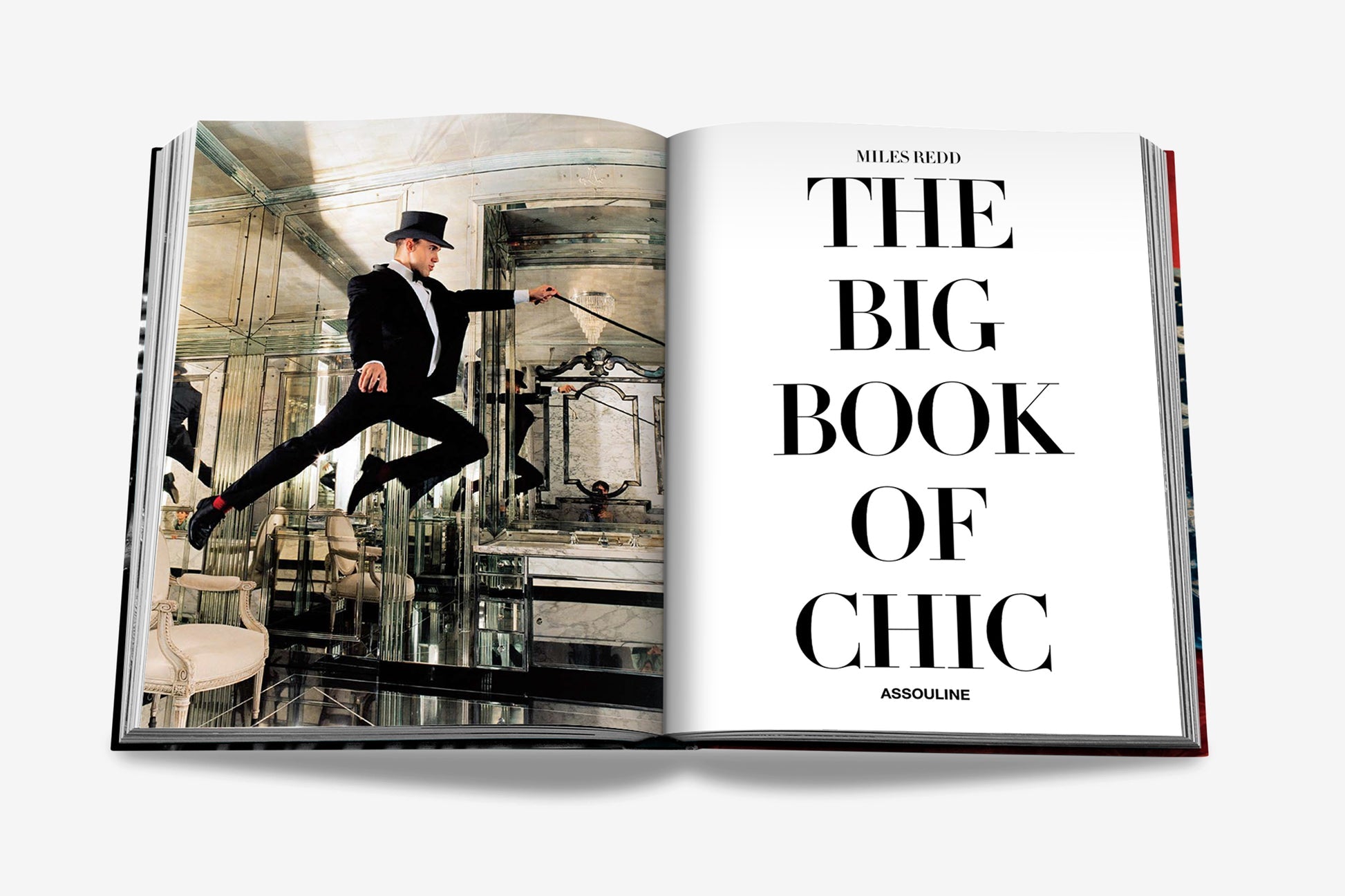 An open book titled "Big Book of Chic" by Assouline showcases a page with a man in a top hat and suit jumping indoors, perfectly capturing the essence of eclectic design.