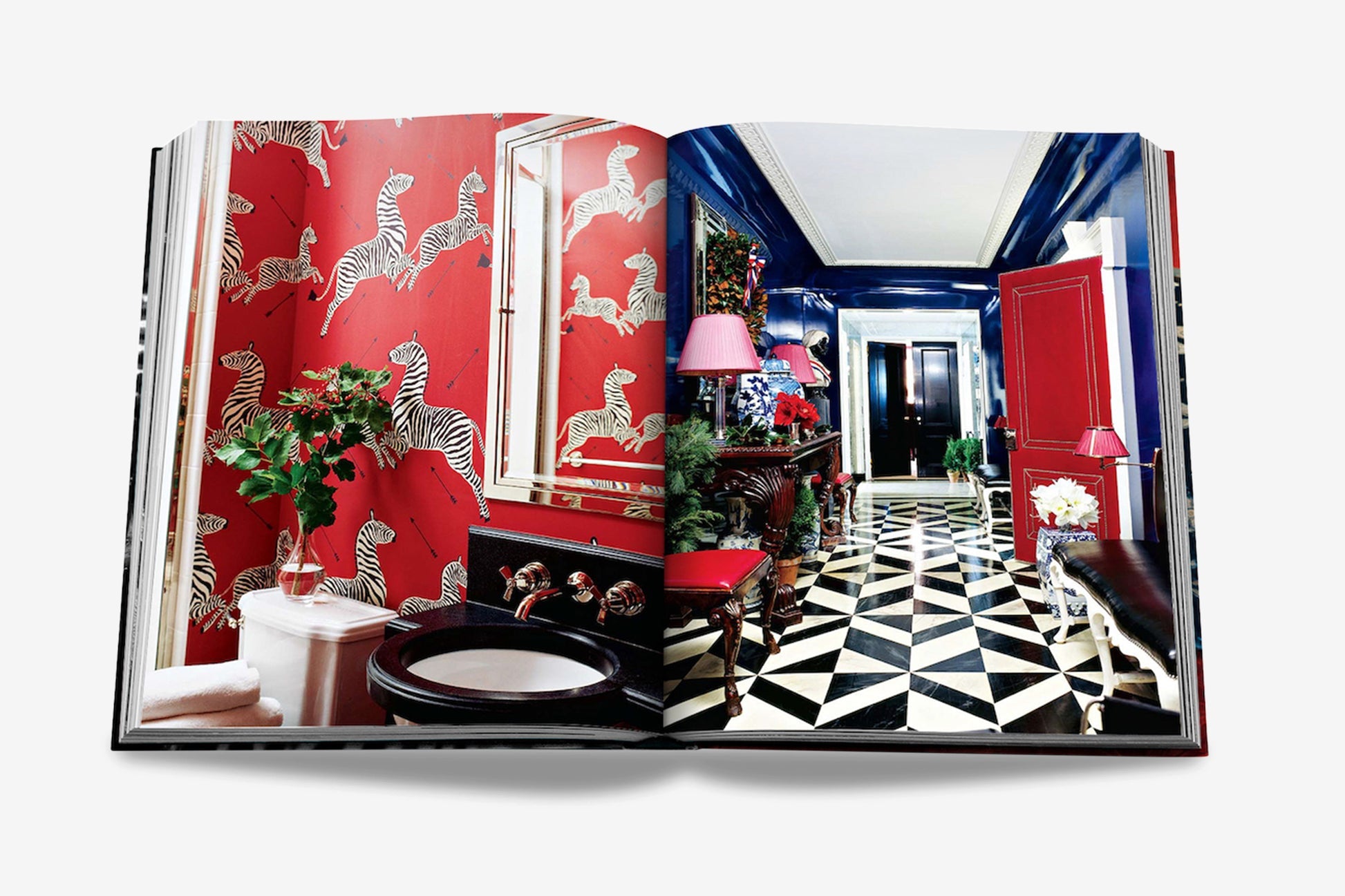 An open book displaying a bathroom with red zebra-patterned wallpaper on the left page and a geometric black-and-white tiled hallway with red accents on the right page, showcasing Miles Redd's signature eclectic design, from Assouline's "Big Book of Chic.