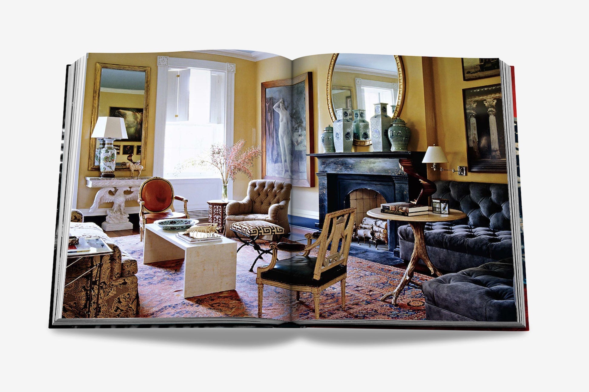 An open book showcases an interior design spread by Miles Redd, featuring a living room with a mix of classic and modern furniture, ornate mirrors, and various eclectic decorative elements. The book is titled "Big Book of Chic" by Assouline.