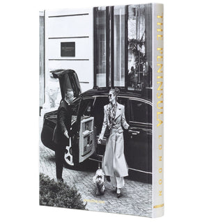 A doorman opens a car door as someone in a long coat walks a small dog outside The Peninsula London by Assouline, an iconic luxury hotel near Hyde Park.