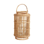The Accent Decor Tindra Lantern boasts a handwoven rattan cylindrical frame, open weave design, glass candle insert, and handle—ideal for adding warmth to weddings or cozy gatherings.