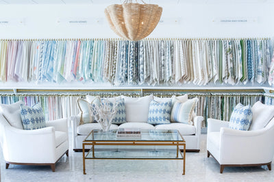 wall of fabric samples and a white sofa, and 2 white chairs at Hive trade showroom