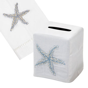 The Starfish Bath Collection, Blue by Haute Home includes a white tissue box cover and matching 13"x18" towel, both in Italian linen with hand-embroidered blue and beige beaded starfish for an elegant touch.