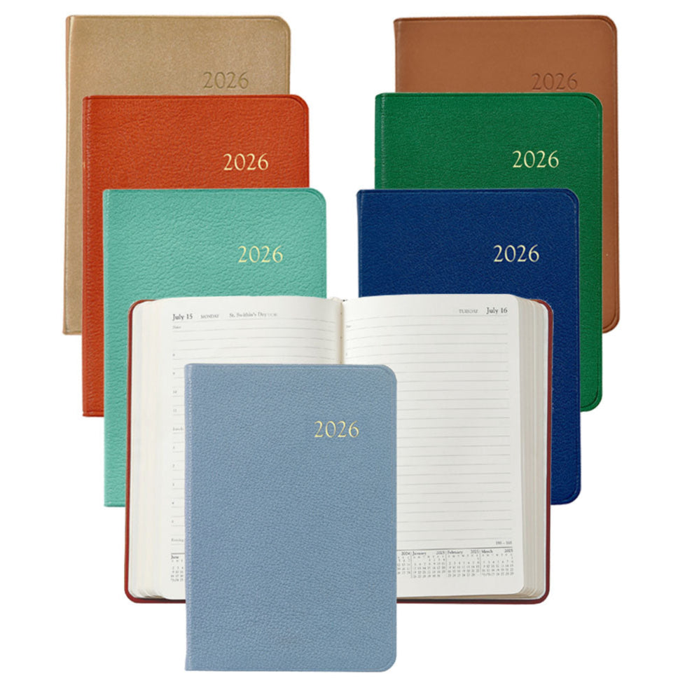 The Graphic Image 2026 Daily Journal Planner Collection features planners in various colors, including a day-at-a-view diary, with one open to display its lined pages and calendar dates.