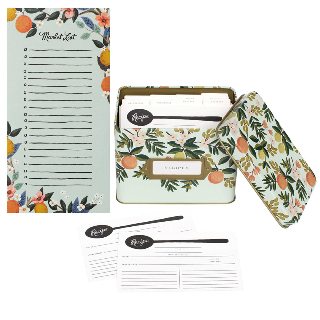 The Rifle Paper Co. Citrus Recipe Tin and Market Pad Collection includes a floral tin with lid, matching recipe cards, and a magnetic pad—all featuring vibrant fruit and botanical designs for stylish kitchen organization.