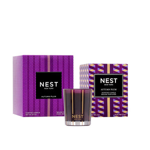 A Nest Autumn Plum Candle Collection premium scented candle is showcased in front of two purple and gold-patterned boxes labeled with the same product name.