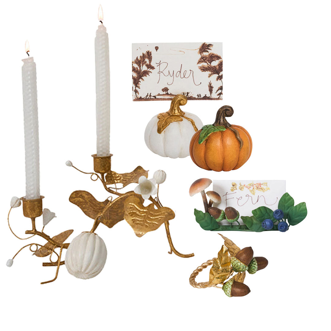 The Forest Walk Tabletop Collection by Juliska features gold candle holders with white candles, white and orange pumpkins, and "Ryder" and "Fern" place cards with whimsical mushroom and flower details for an elegant tablescape.