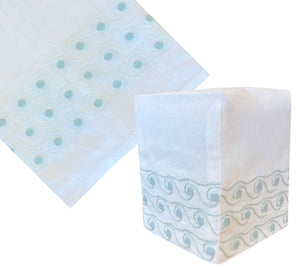 The Haute Home Breakers Bath Collection in Aqua features an Italian Linen tissue box cover with light blue hand-embroidered wavy and dot patterns near the bottom, shown both flat and on a box.