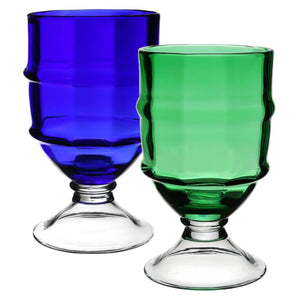 The Cotswold Footed Hurricane Collection by William Yeoward Crystal features expertly crafted glasses in blue and Apple Green, both with clear bases and a ribbed design that highlights fine glassblowing artistry.