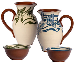 Two ceramic pitchers and two bowls from the Marbre Serveware Collection by Sharland England, featuring green and blue marbled patterns with brown handles and bases, are displayed on a white background.