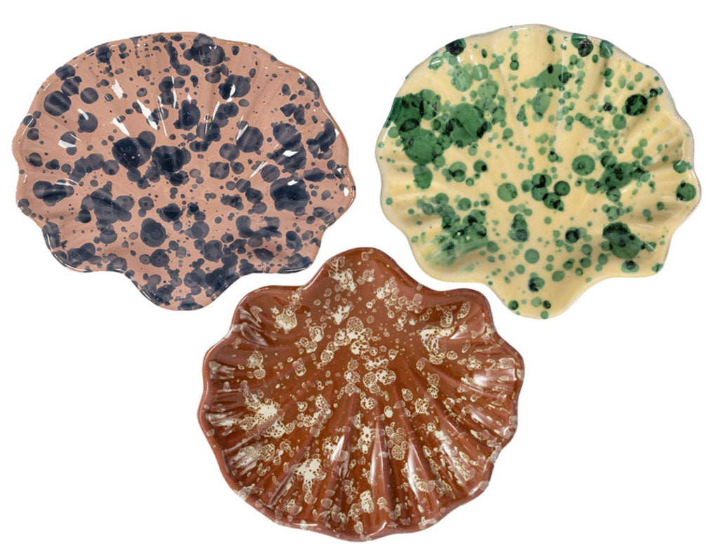 The Splatter Coquillage Dish Collection by Sharland England features three handmade Italian ceramic plates with wavy, shell-inspired edges and unique splattered patterns—a chic gift for any occasion.
